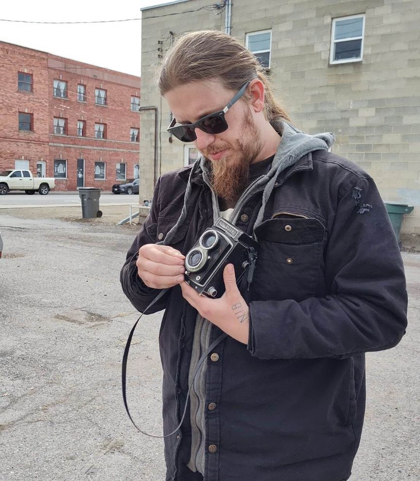 Man with vintage camera in alley